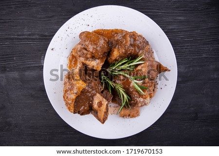 Meat on the bone baked with spices is served with sauce