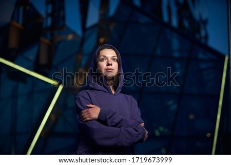 Attractive woman dressed in a hoodie downtown in the city.