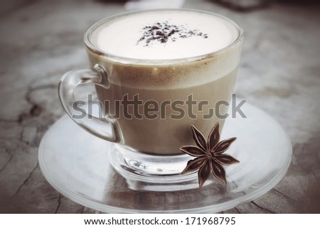 Cup with hot cappuccino on wood