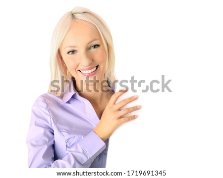 Portrait of a beautiful woman holding a blank billboard, looking out from behind it. Beautiful smiling businesswoman. elegance office worker.