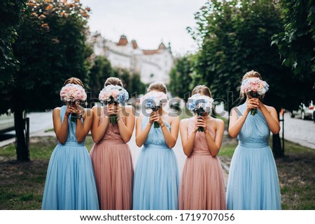 Bridesmaids at wedding with bouquets in hands. Girl in colored dresses for wedding. Royalty-Free Stock Photo #1719707056