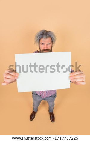 Advertising banner. Copy space for text. Advertising board. Surprised man with blank board. Space for text. Bearded man holds empty board. Handsome man shows empty board. Ready for your text.