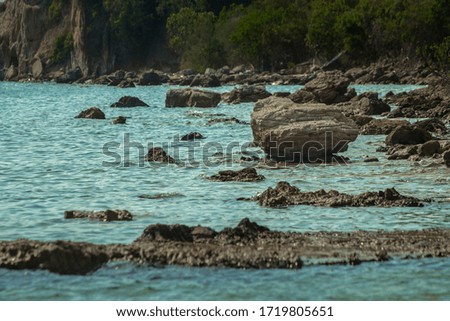 Huge rock cliff and blue sea with blue sky background