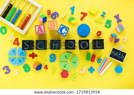 Colorful math fractions on yellow,  background. Blocks with title School on the table. Interesting, fun math for kids. Education, back to school concept	