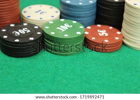 casino chips on green field background, selective focus