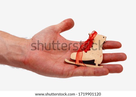 Male hand holding wooden ice skate isolated on white background. Minimalistic concept.