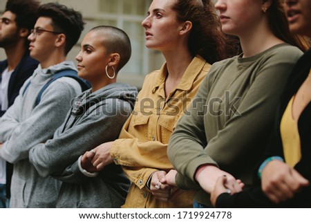 Group of protestors standing together holding hands in protest picket. Male and female activists protesting silently. Royalty-Free Stock Photo #1719924778