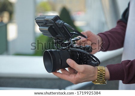 Man holding gimbal stabilizer outdoor. Gimbal Operator with black equipament - Stabilizer and camera filmmaking . An unidentified man holding gimbal a camera stabilizer .
