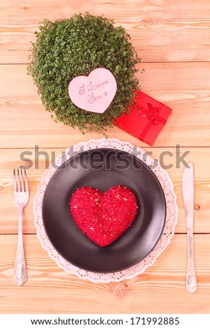 Still-life with heart on a plate and valentine decorations, toned