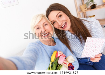 Cute grandma is hugging her daughter and making selfie