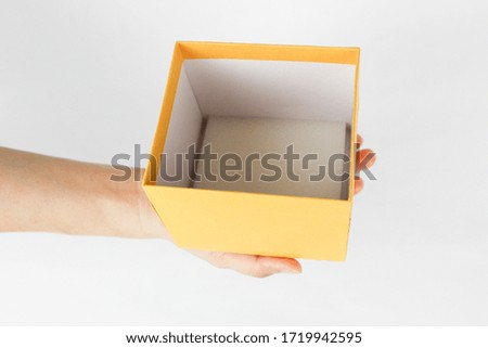 Holding a yellow box on the hand at the white background
