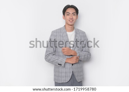 Young handsome businessman wearing striped gray suit standing over isolated white background