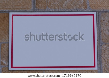 Empty information sign on old brick wall. White color