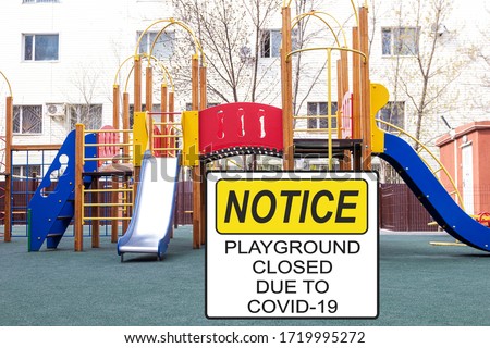 ''Notice. Playground closed due to COVID-19'' information sign against a closed playground