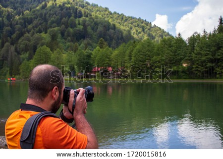Man taking pictures in forest by the lake