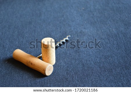 corkscrew and cork for wine on a blue board