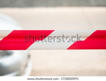 striped red-white warning ribbon, outdoor shot with the blurred background and foreground