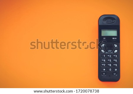 Wireless cordless telephone, radiotelephone, dect cordless phone wireless phone, radiotelephone, radio phone on orange background Royalty-Free Stock Photo #1720078738