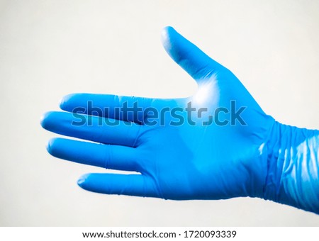 Close up hand in blue glove on white background in science concept.