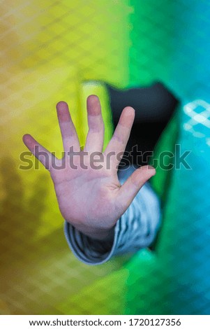 A hand in front of colorful wrapping paper