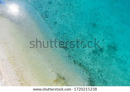 View from above, stunning aerial view of a beautiful beach and clear emerald green sea.
