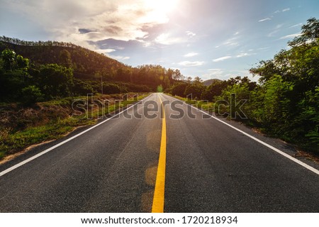 Empty asphalt road through the green field and clouds on blue sky in summer day.  Royalty-Free Stock Photo #1720218934