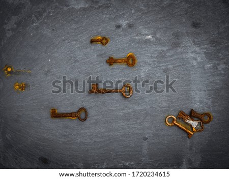 keys with rust marks photographed from above on a black stone background