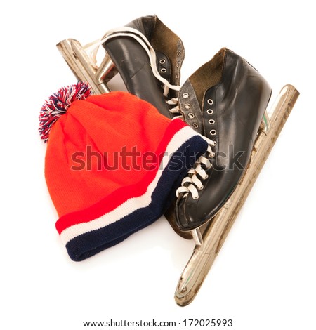 Used male ice skates and orange dutch hat isolated over white background