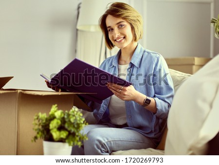 Young woman moving out and packing cardboard box