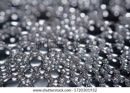 An image of background with water droplets on mirror in black and white tone with blur bokeh behind