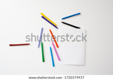 Scattered crayons of different colors on a white background