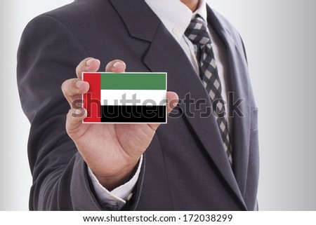 Businessman in suit holding a business card with United Arab Emirates Flag 