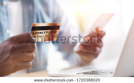 Collage with African American guy holding loyalty card while doing online shopping at home, close up. Panorama Royalty-Free Stock Photo #1720388020