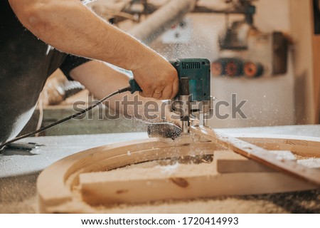 Joinery, woodworking and furniture making, professional carpenter cutting wood in carpentry shop, industrial concept Royalty-Free Stock Photo #1720414993