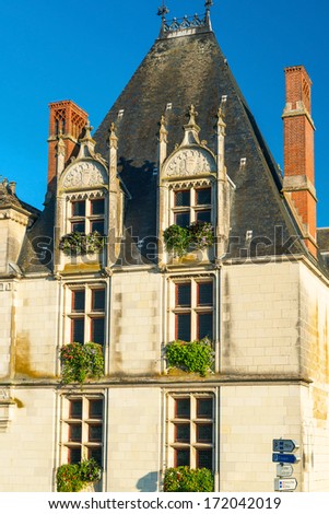 Vintage house on a street in the ancient town of Amboise, France. Old residential house with flowers on the windows in summer.