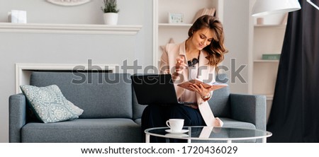 Working mom view flatlay of workplace usingd laptop with phone and the notebook