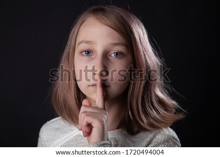 Girl isolated on black background showing shh silence sign