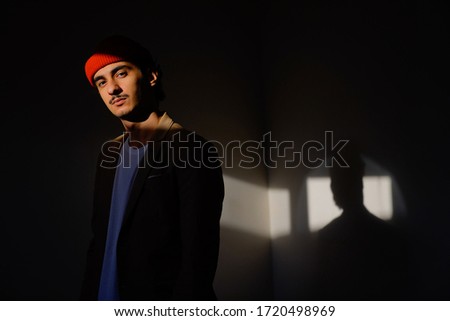 Day light portrait of a young man. The portrait is a Low key 