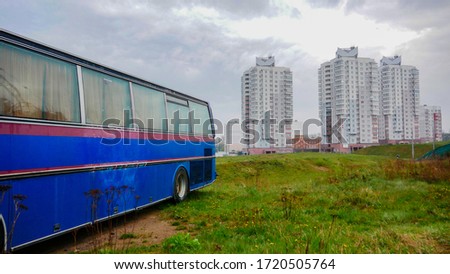 long blue bus on the background of buildings