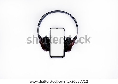 Black headphones with the phone isolated on white background.