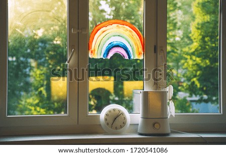 Painting rainbow on window. Rainbow painted with paints on glass is a symbol for many meanings.