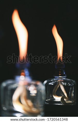 A vertical shot of the flames of scent diffusers in the dark