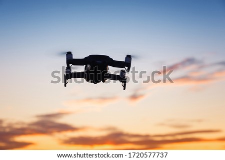 Silhouette drone against the background of the sunset