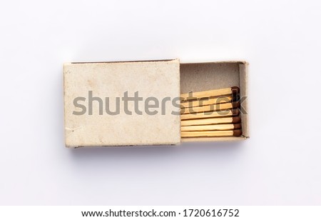 Opened old box of matches isolated on white background, top view. One burnt wooden match among the new ones. Space for design on cardboard box.