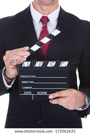 Close-up Of A Businessman Holding Clapperboard Over White Background