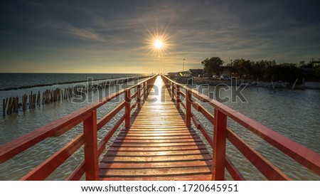 Red bridge in the evening with a beautiful sunset, Dolphin viewpoint, Samut Sakhon, Thailand.