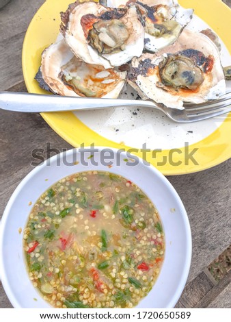 Pictures of grilled oysters with seafood dipping sauce are delicious food in the fishing village of Thailand.