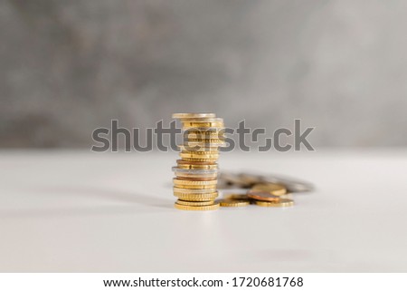 pile coin in the front and coins in the background out of focus