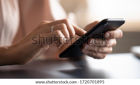 Close up female hands holding phone, typing on screen, young woman using smartphone, chatting in social network, writing message, browsing mobile device apps, blogger posting in blog Royalty-Free Stock Photo #1720701895