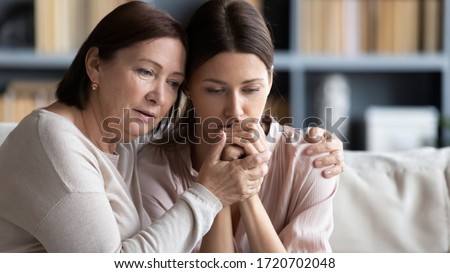Loving middle aged mother hugging comforting sad adult grown up daughter, caring mature mum soothing unhappy upset young woman, expressing empathy and support, helping overcome problems Royalty-Free Stock Photo #1720702048